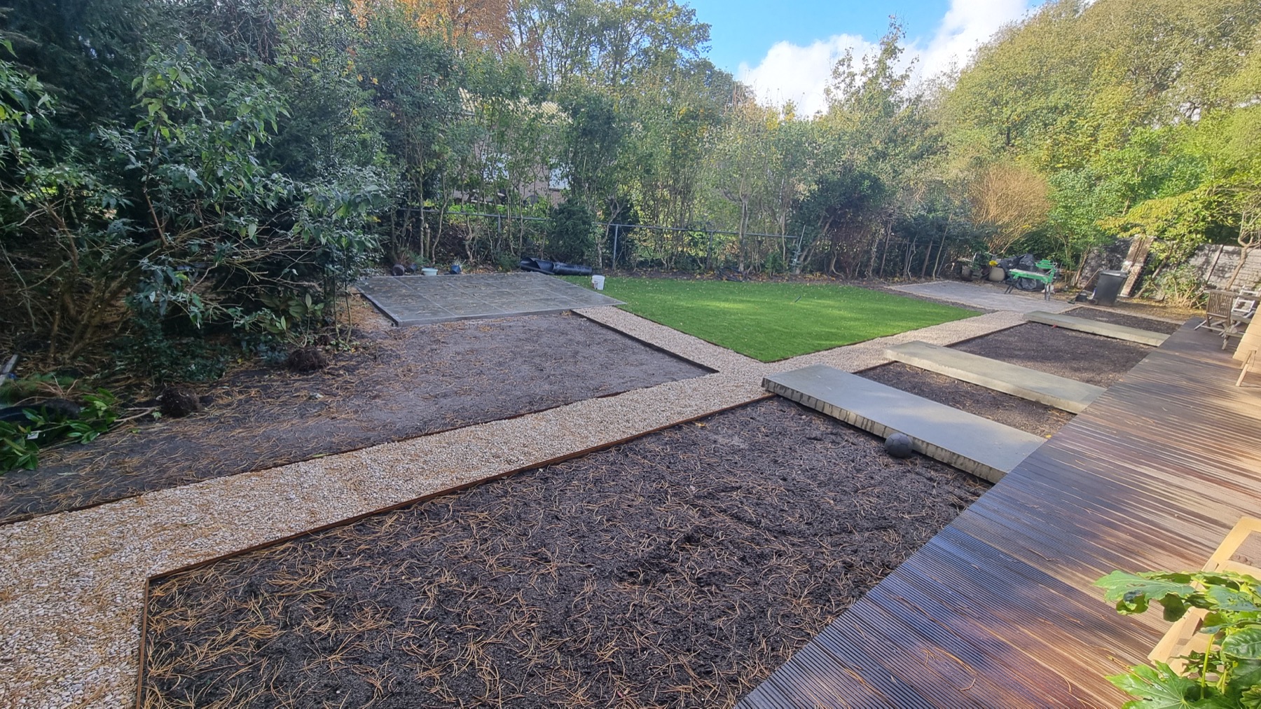 Grote tuin met grindpad, gras en terraszones